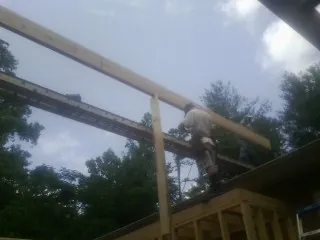 Carpenter setting a ridge beam over a new addition frame — Ice Dam Removal by Roofing Brothers in Dupont