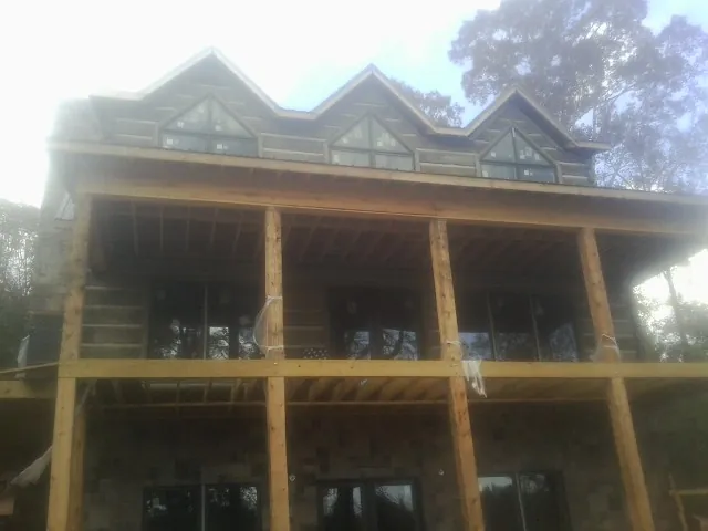 Dormers and porch framing on a large log home under construction — Roof Coating work by our crew in Dupont