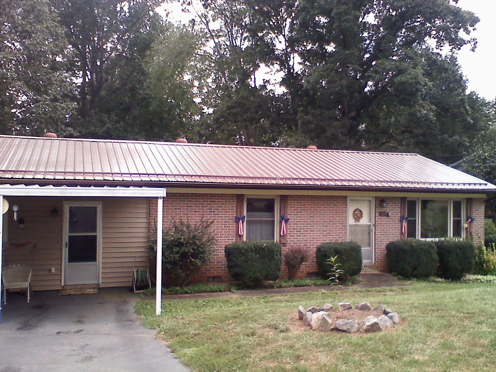 Bronze metal roof and carport on a brick ranch home — Roof Repair work by our crew in Dupont